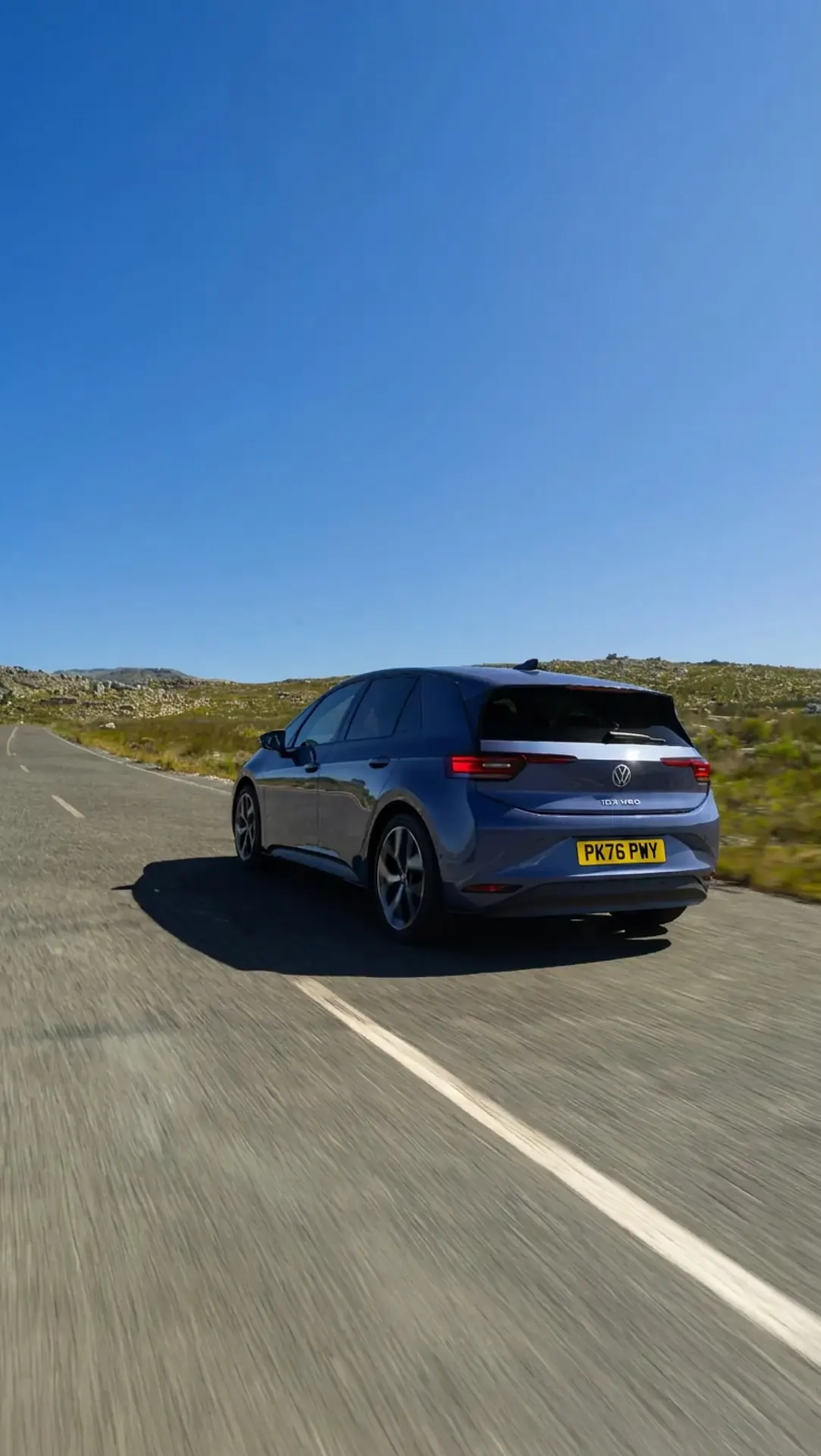 Rear view of a purple Volkswagen ID.3 Neo travelling along a country road