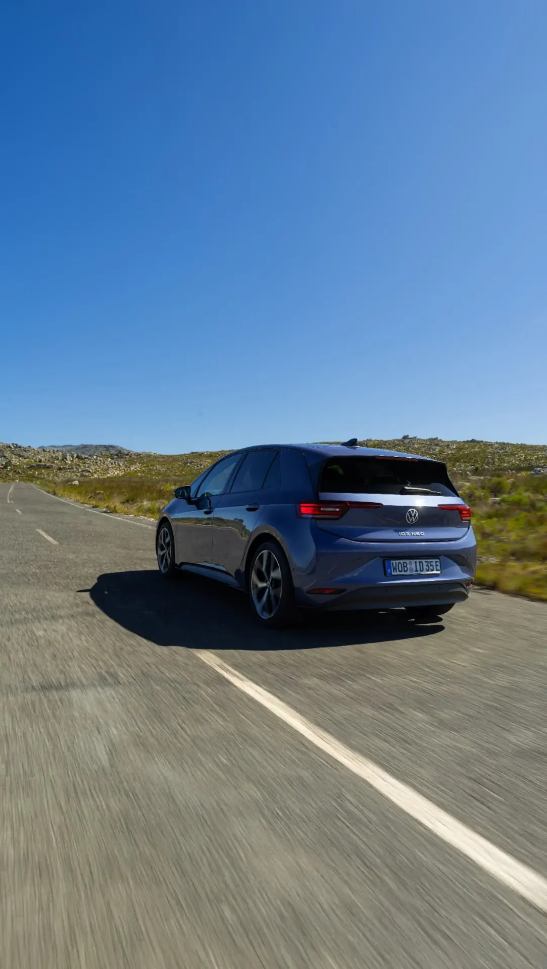 Rear view of a purple Volkswagen ID.3 Neo travelling along a country road